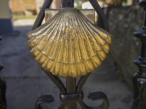 Gold Camino shell mounted on iron gate
